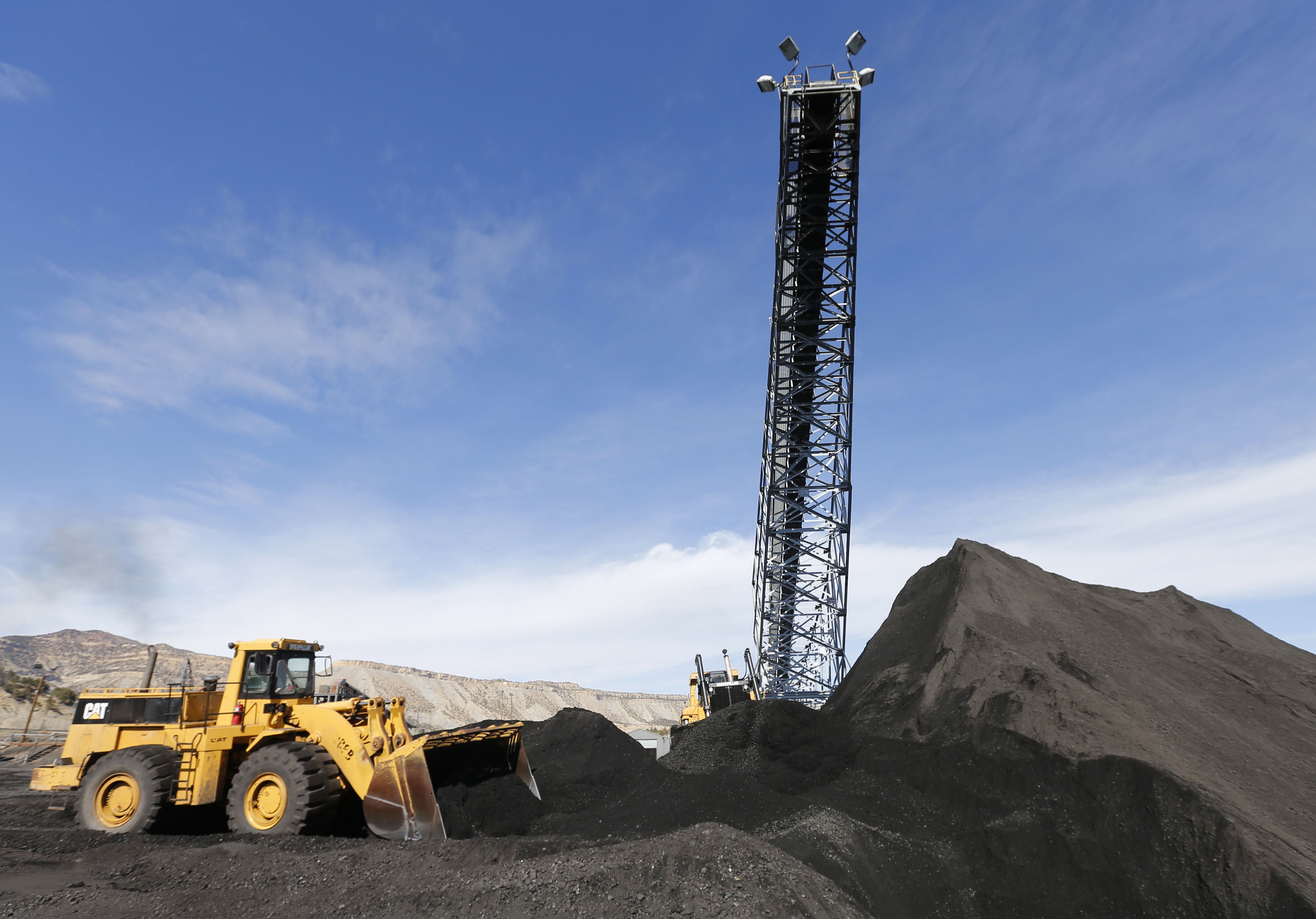 Two Caterpillar earth movers move piles of coal at the Wildcat Coal Load-Out Terminal, owned by Intermountain Power Agency, outside Price, Utah on March 5, 2014.
