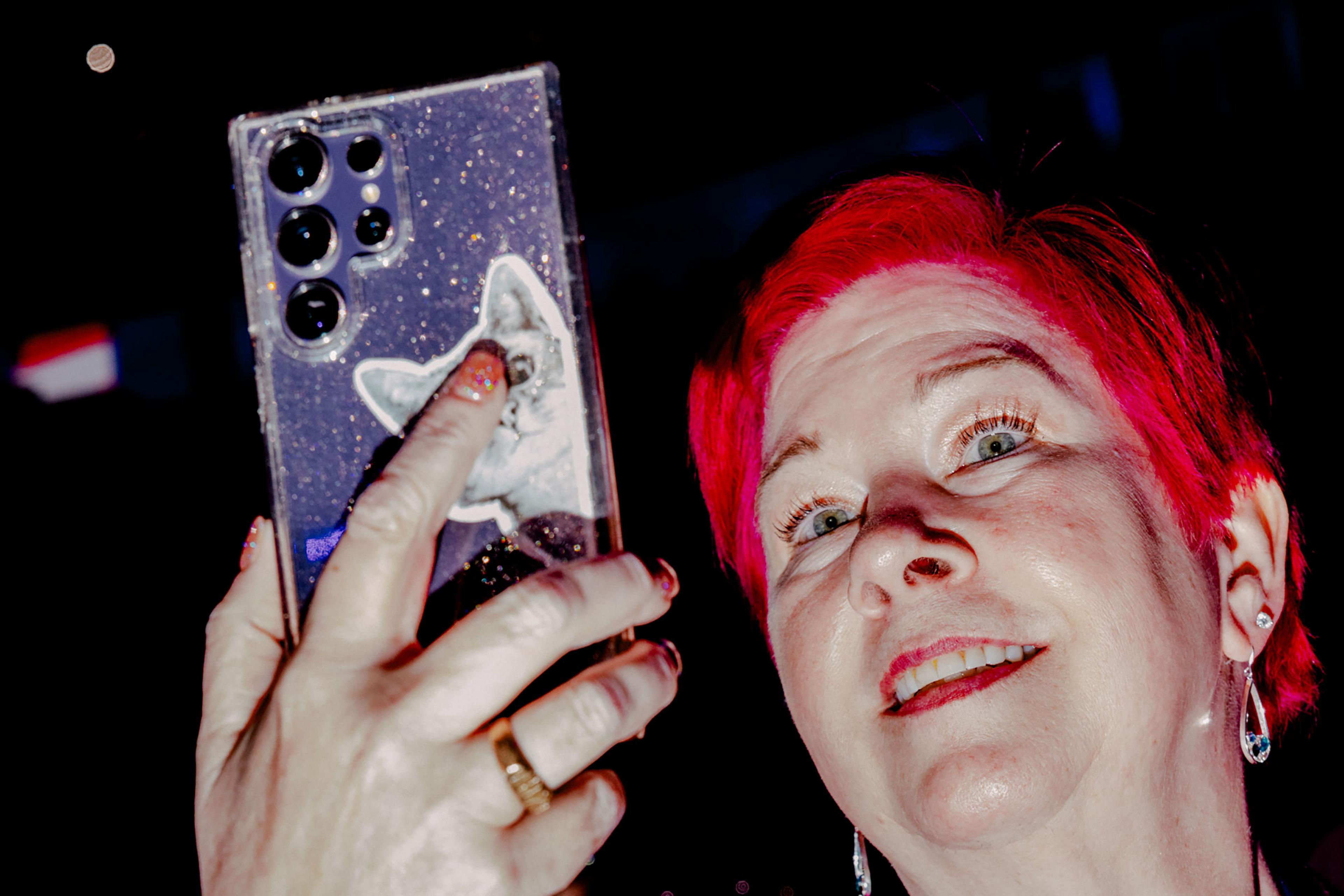 Day 3: An attendee with a cat phone case records on their phone, Aug. 21