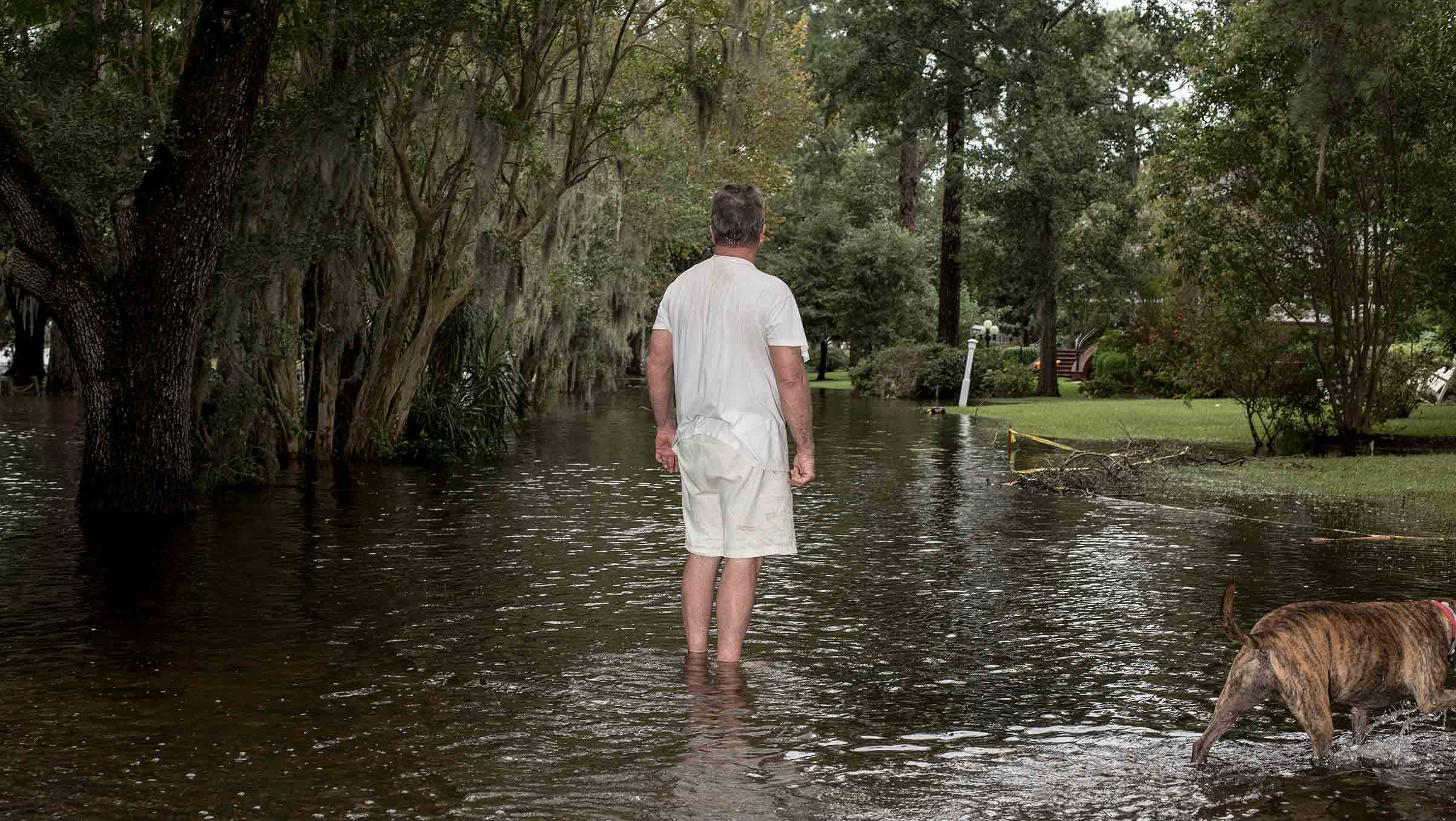 Lee Roy Scott with his dog Bella (right) poses for a portrait while surveying damage to his neighborhood due to storm surge flooding from Hurricane Florence in Washington, N.C. on Saturday, September 15, 2018.CREDIT: Bryan Anselm/Redux for Time