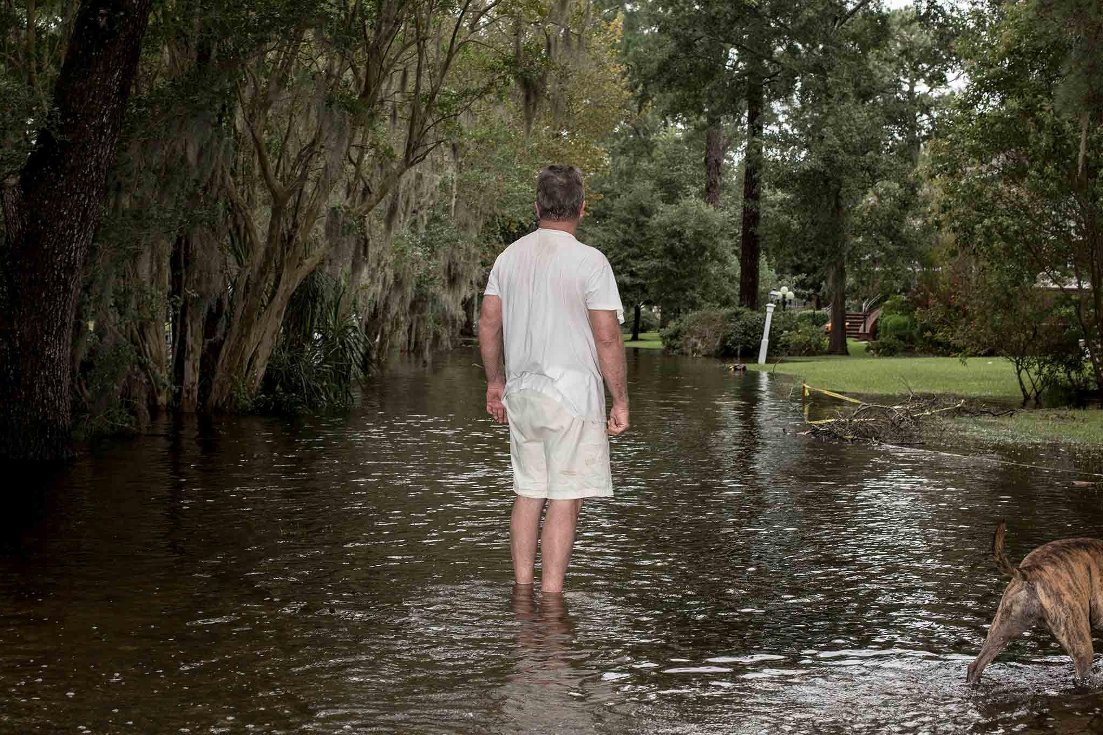 Lee Roy Scott with his dog Bella (right) poses for a portrait while surveying damage to his neighborhood due to storm surge flooding from Hurricane Florence in Washington, N.C. on Saturday, September 15, 2018.CREDIT: Bryan Anselm/Redux for Time