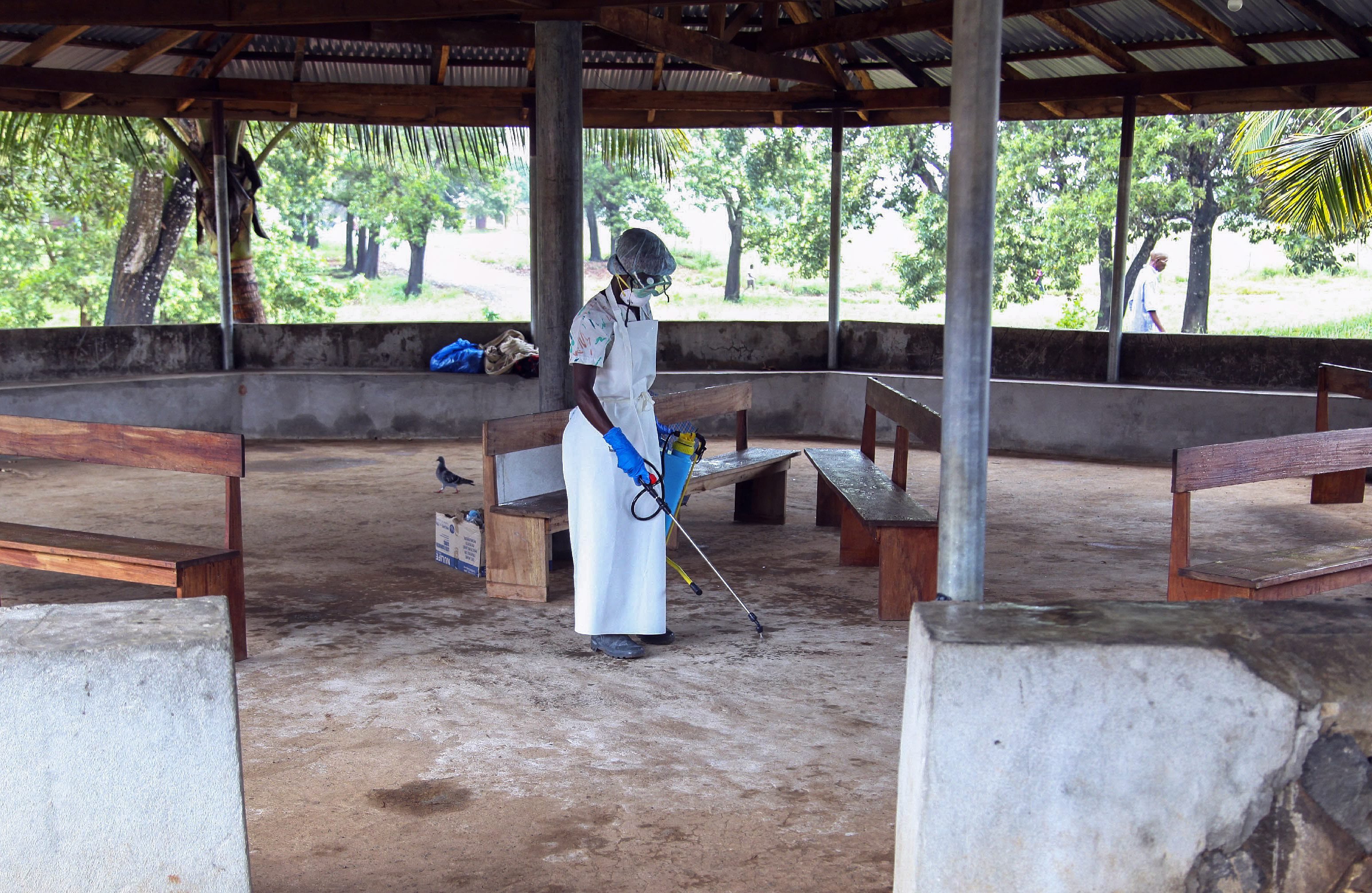 A nurse from Liberia sprays preventives to disinfect the waiting area for visitors at the ELWA Hospital where a US doctor Kent Bradley is being quarantined in the hospitals isolation unit having contracted the Ebola virus, Monrovia, Liberia, 28 July 2014