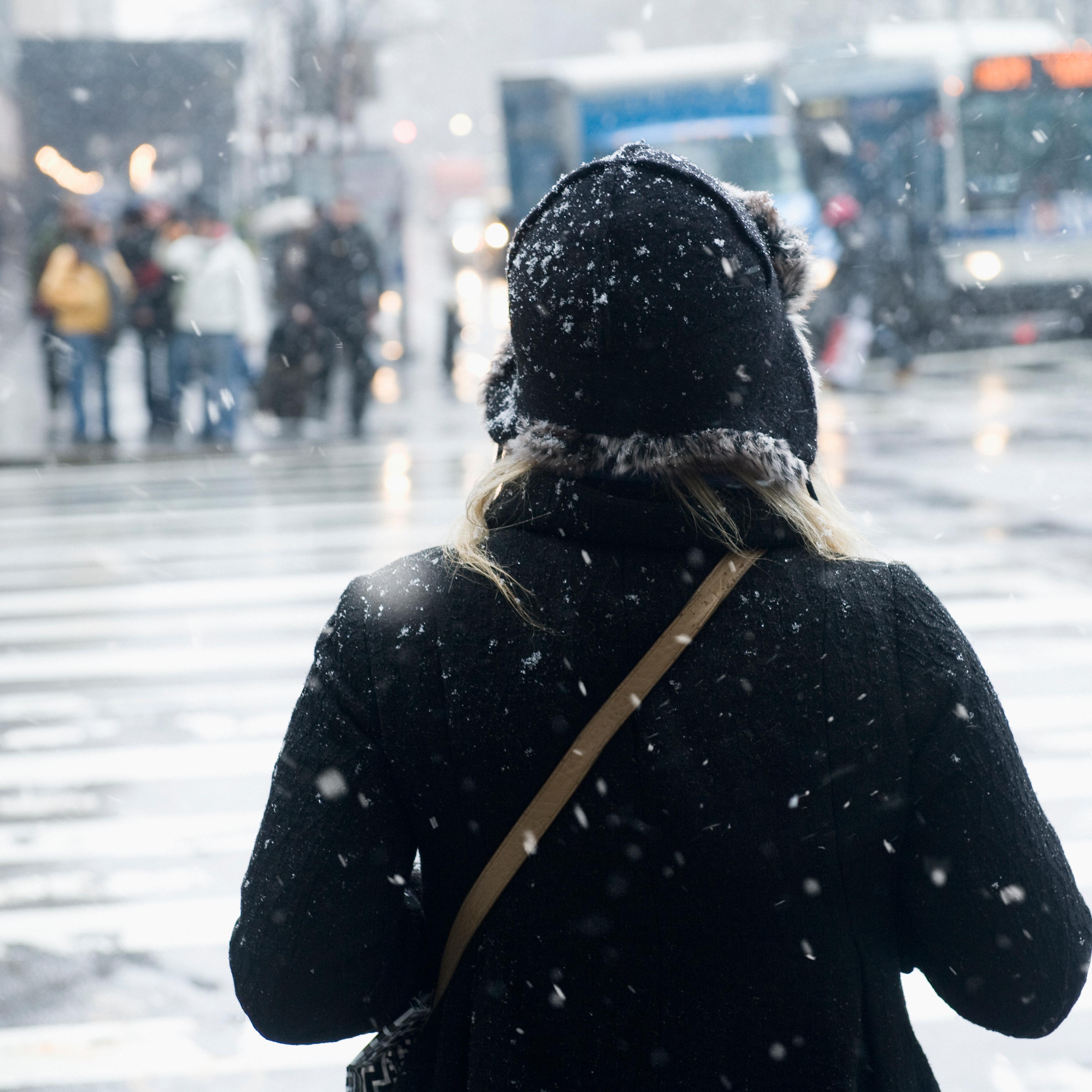 Young woman about to cross the street in snow