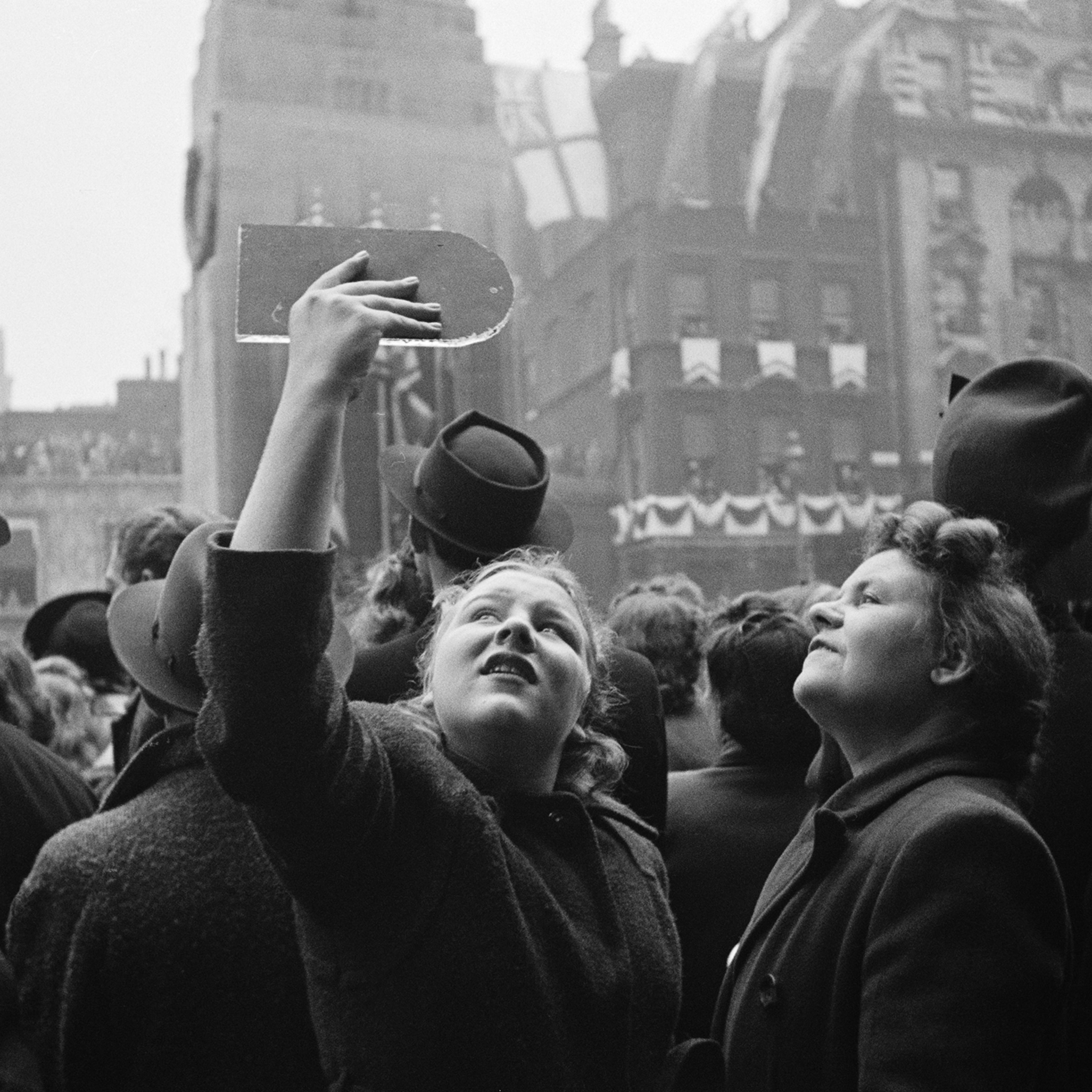 Spectators use hand-held mirrors to see over the crowd during the wedding of Queen Elizabeth II and Prince Philip, Duke of Edinburgh, at Westminster Abbey in London, Nov. 20, 1947.