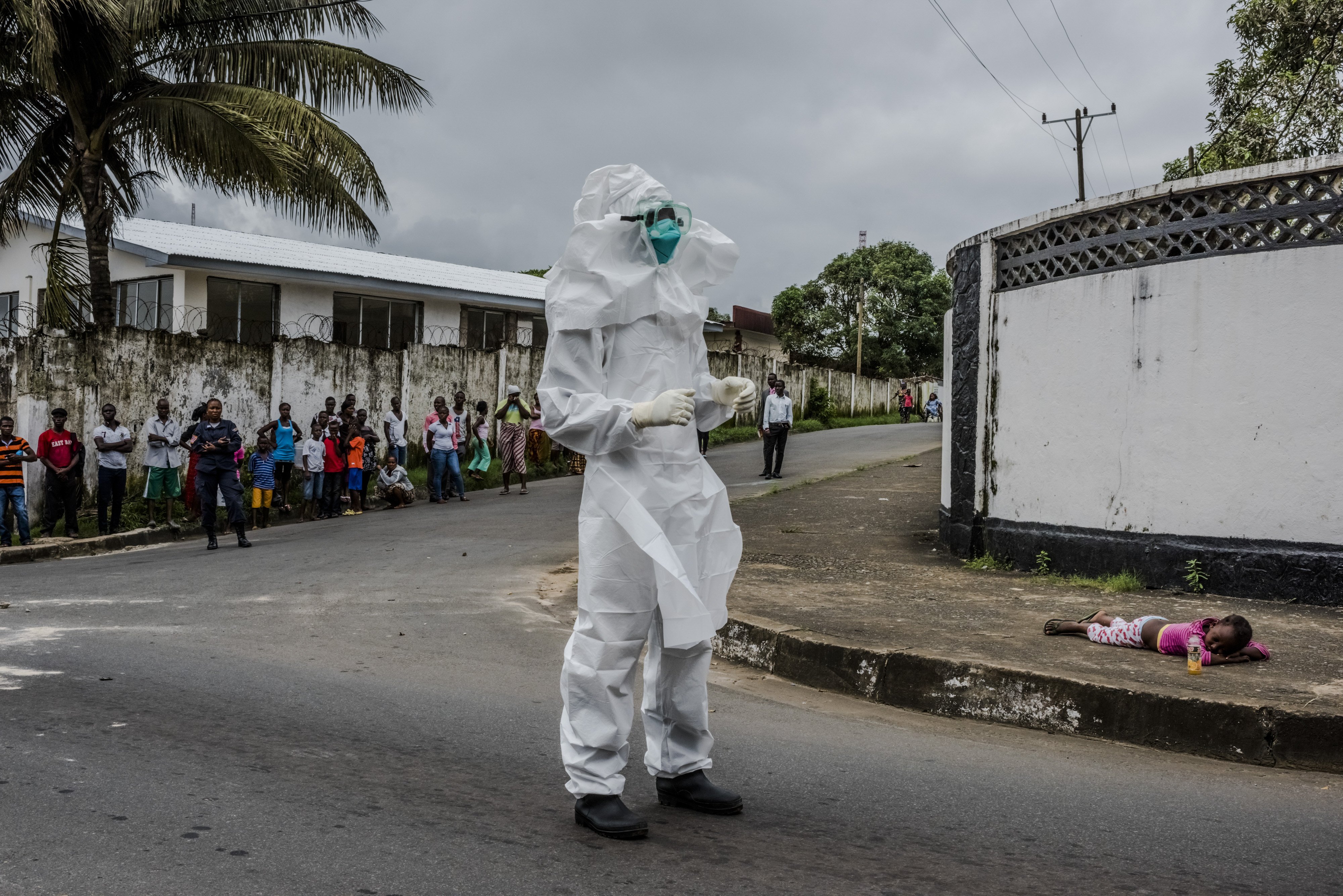 A girl suspected of having Ebola lies on a sidewalk, where her aunt left her after she was unable to get help, in Monrovia, Liberia, Aug. 31, 2014.