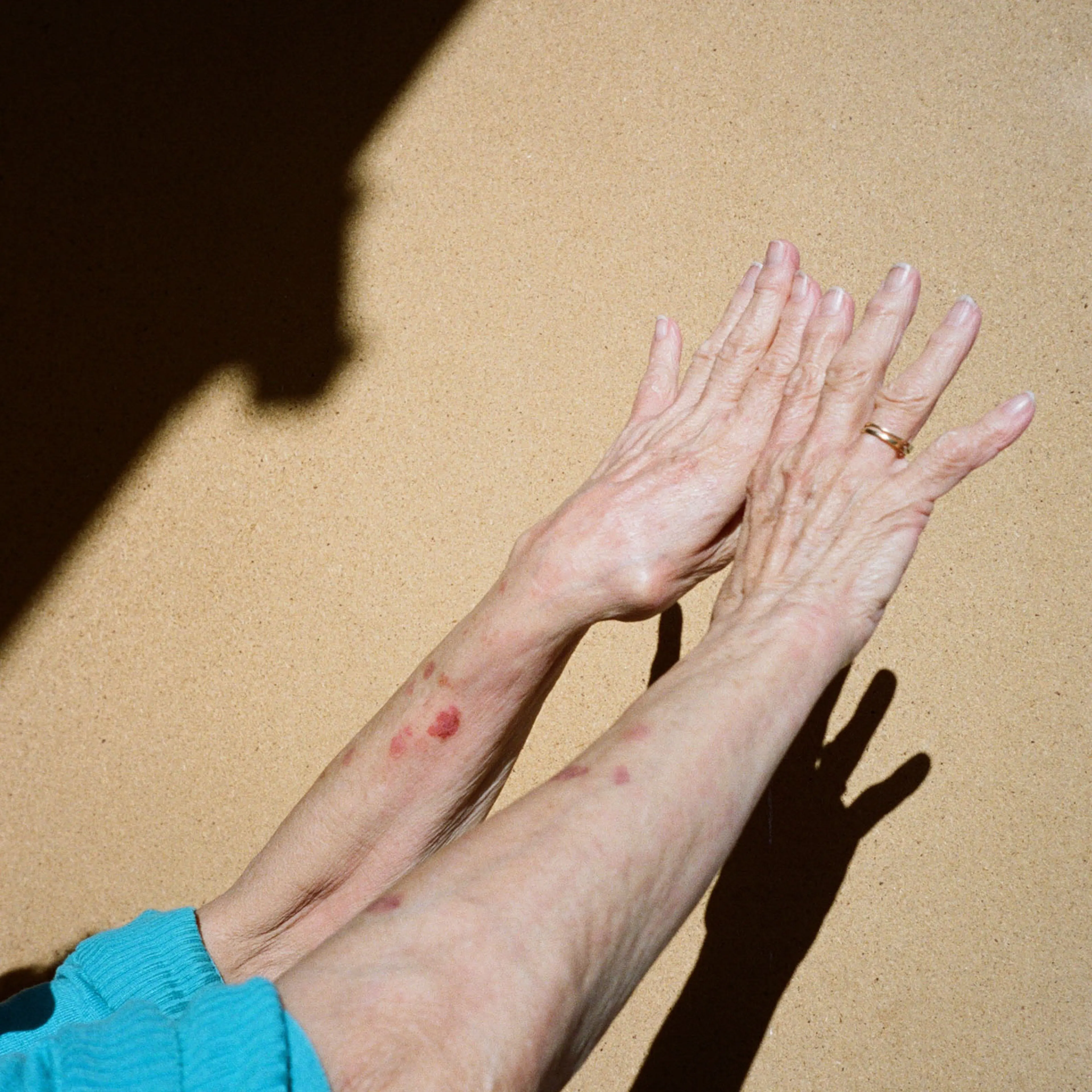 Older hands reaching into the sunlight