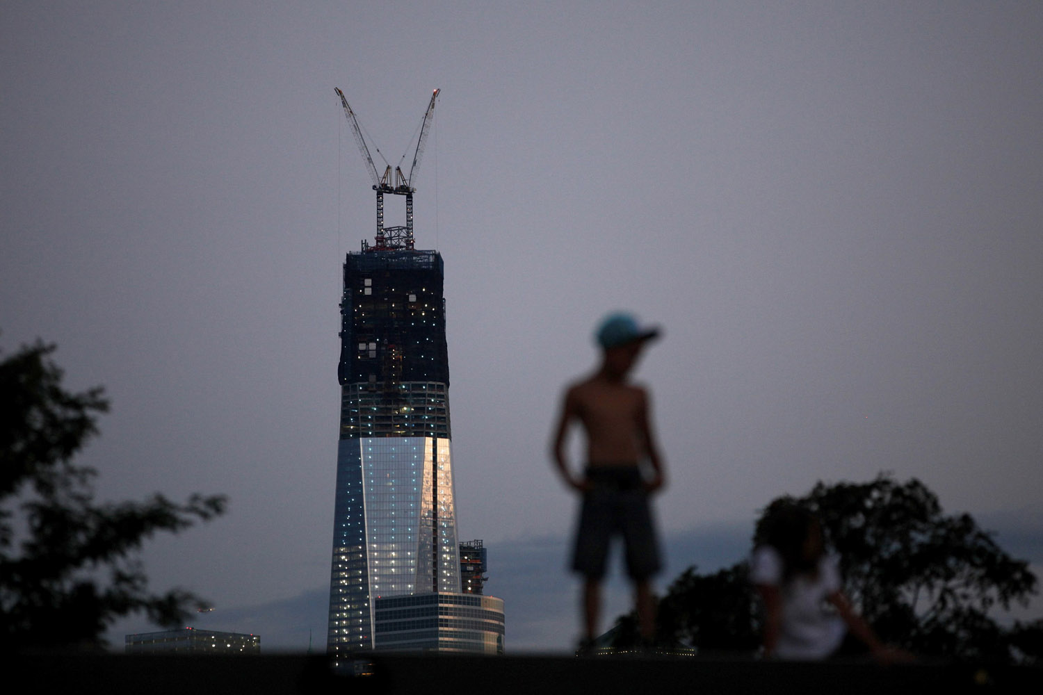 Sept. 9, 2012. One World Trade Center stands tall on the skyline of New York's Lower Manhattan as a boy stands on a pier in Hoboken, N.J.