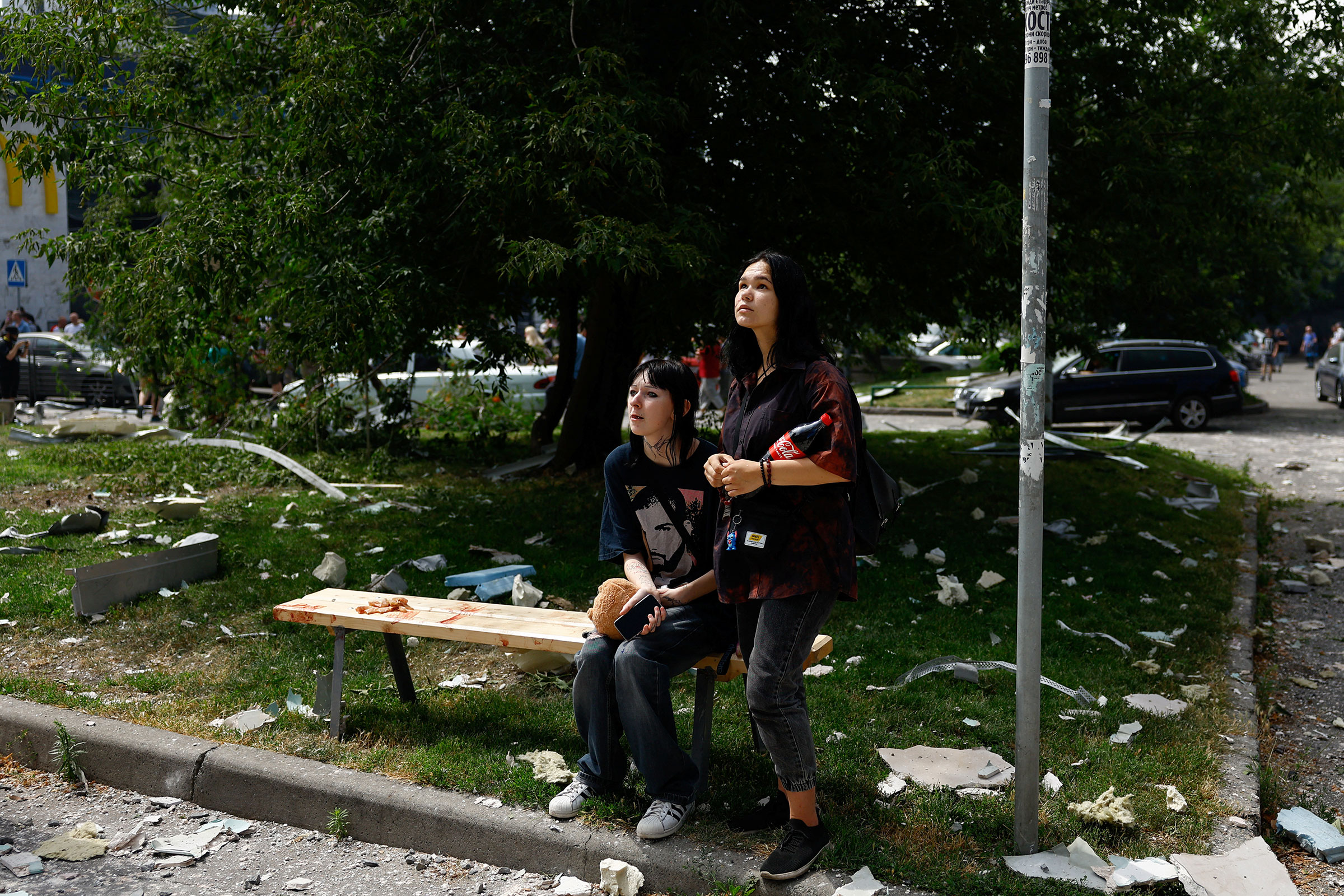 Women react near a building damaged during Russian missile strike, in Kyiv