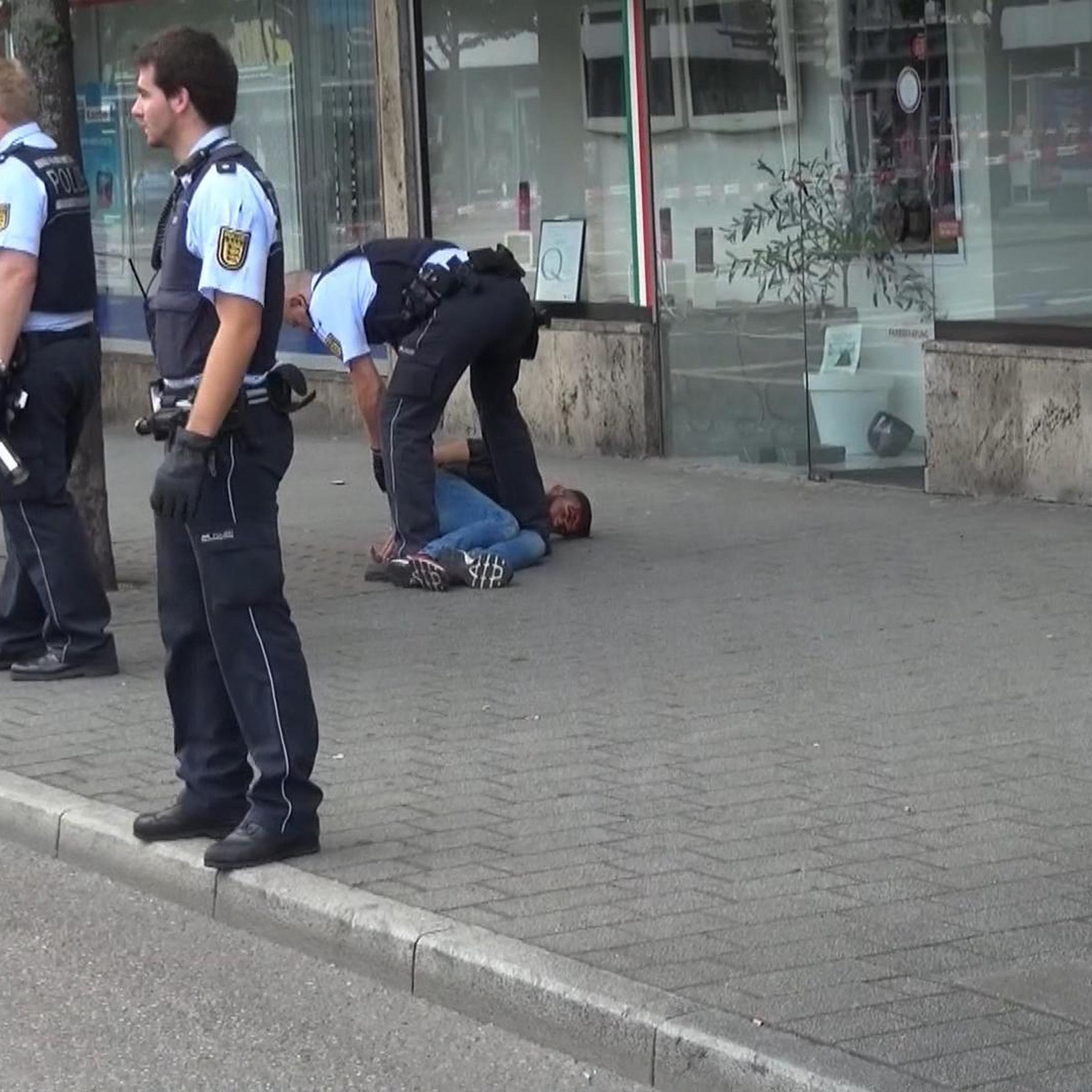 Police officers arrest a man close to a machete, front right, after an attack in Reutilingen, Germany, July 24, 2016.
