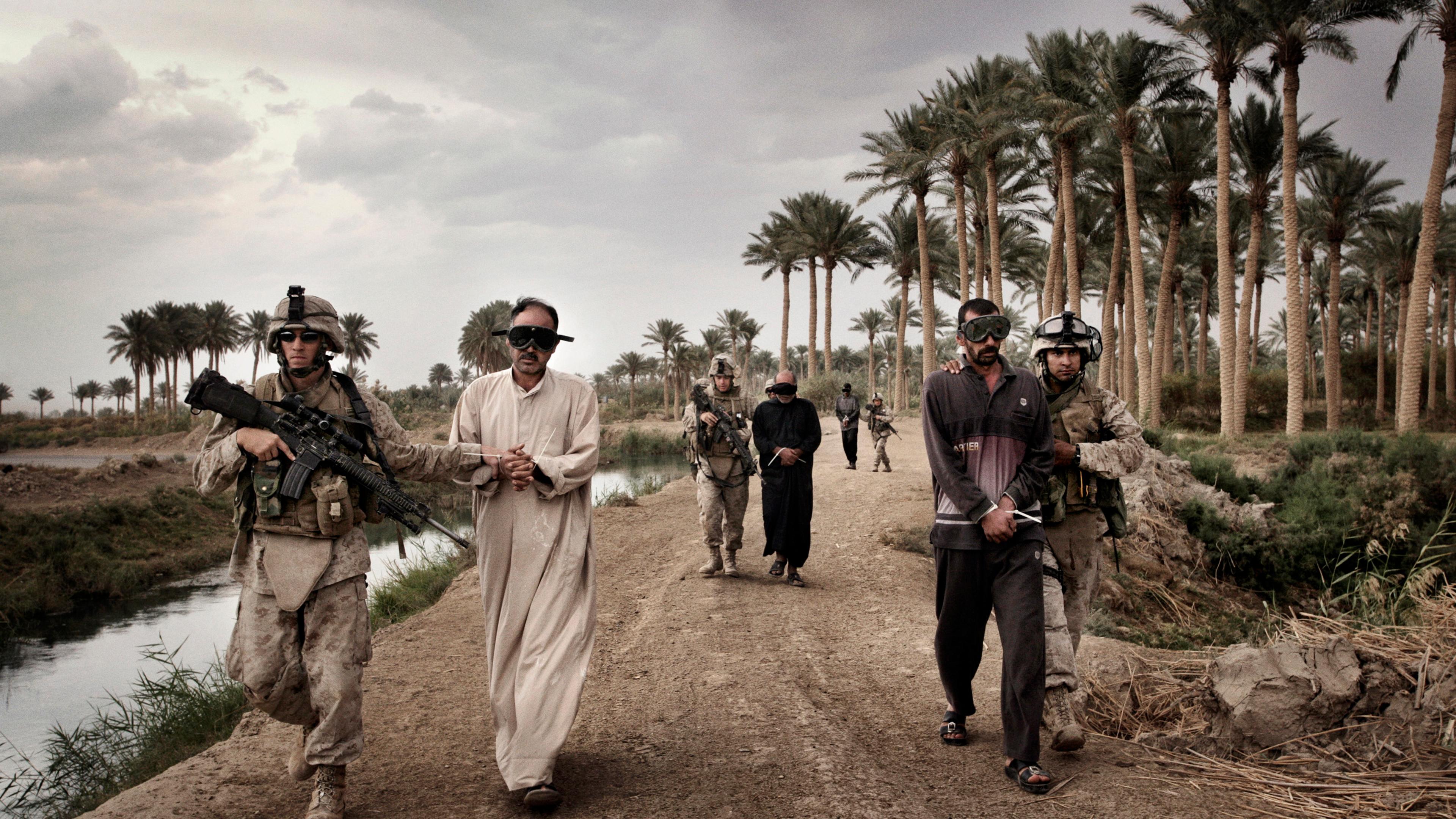 Marines escort suspected insurgents, including Ali Muhammad Said, accused of leading a mortar team in attacking Camp Delta outside al-Karmah, Fallujah, Iraq, Oct. 29, 2005.