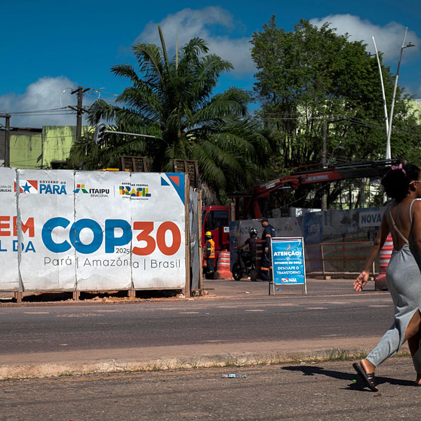 A woman walks past an infrastructure project underway for COP30 in Belem, Brazil