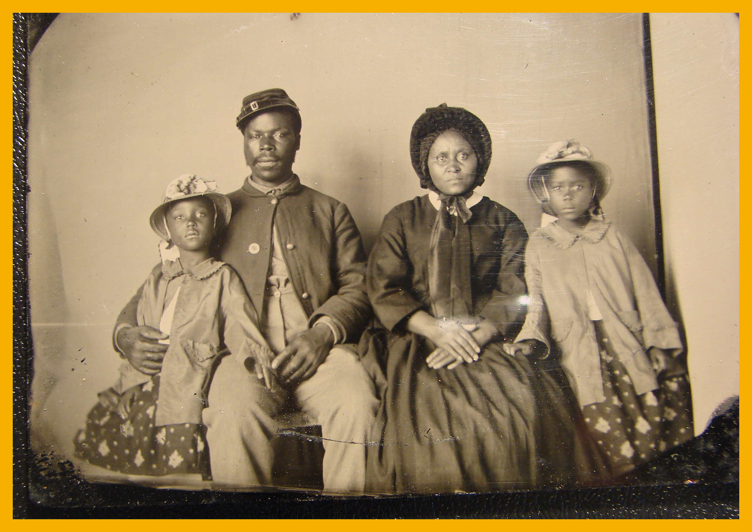 African American soldier in Union uniform with wife and two daughters, circa 1863 - 1865.