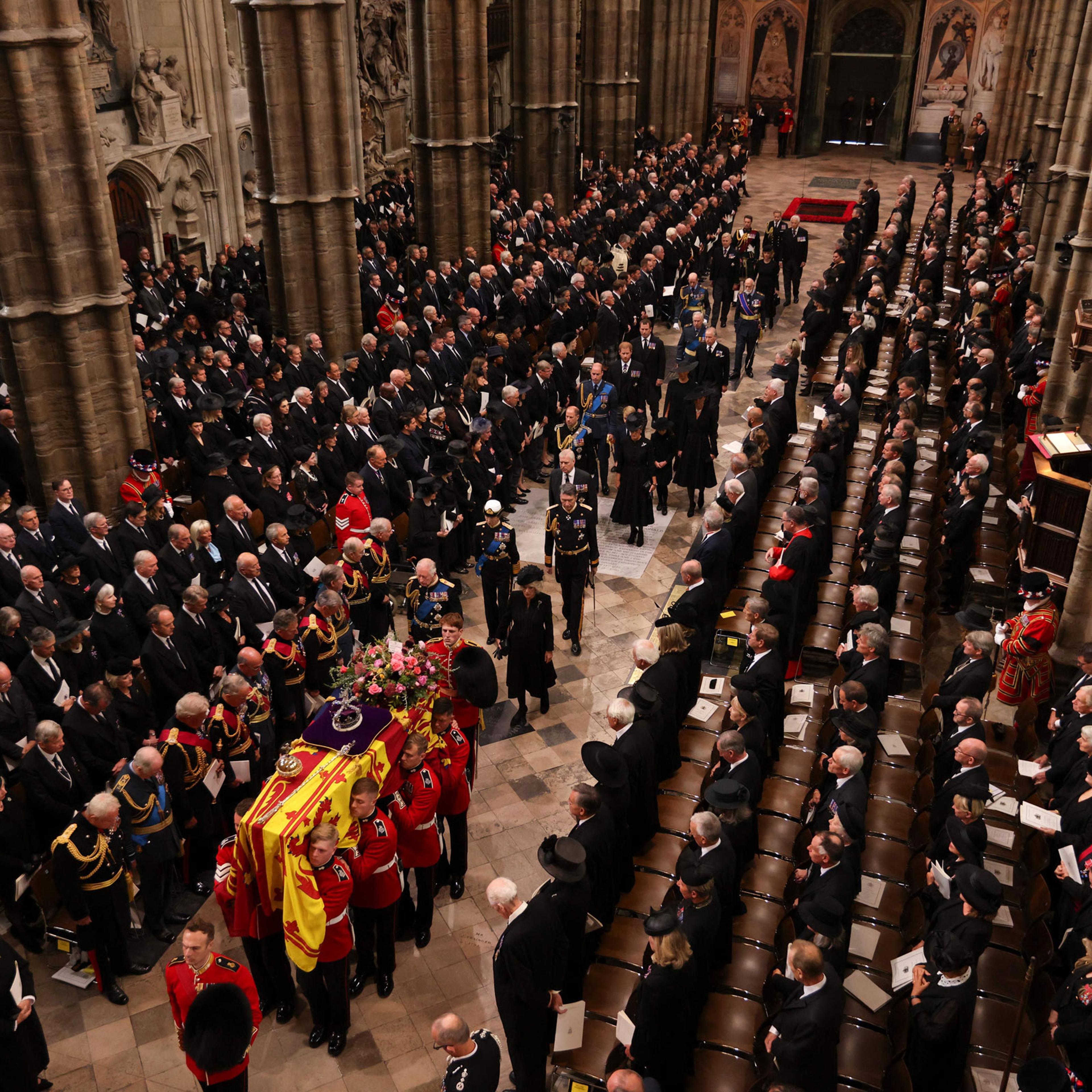 A Bearer Party of The Queen's Company, 1st Battalion Grenadier Guards carries the coffin of Queen Elizabeth II, draped in the Royal Standard, into Westminster Abbey in London on September 19, 2022, ahead of the State Funeral Service.
