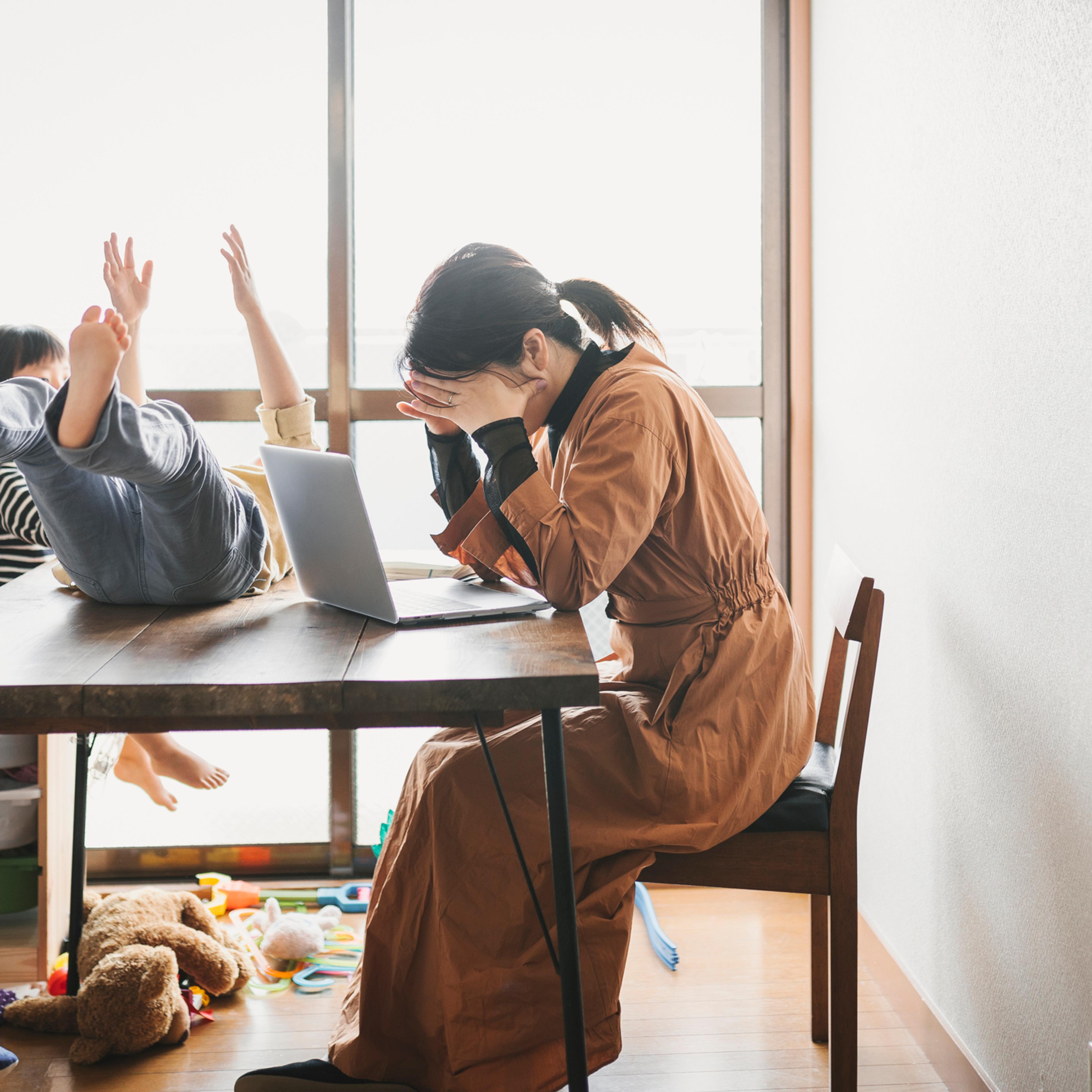 Mother working from home with children