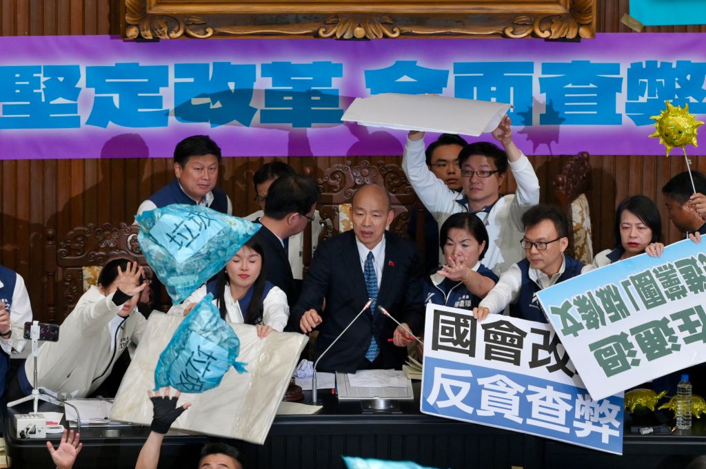 Lawmakers from main opposition Kuomintang (KMT) stop garbage bags thrown by ruling Democratic Progressive Party (DPP) legislators during voting for the Parliament reform bill in Taipei on May 28, 2024.